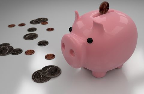 Ein Sparschein, um das viele Münzen verteilt liegen