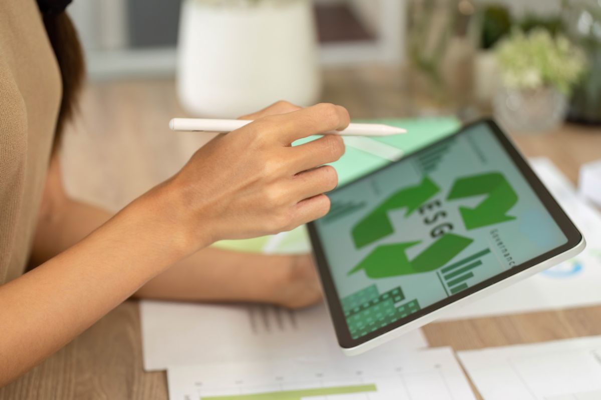 Das Bild zeigt eine Person, die mit einem Stylus auf einem Tablet arbeitet. Auf dem Bildschirm des Tablets sind grafische Darstellungen zu sehen.