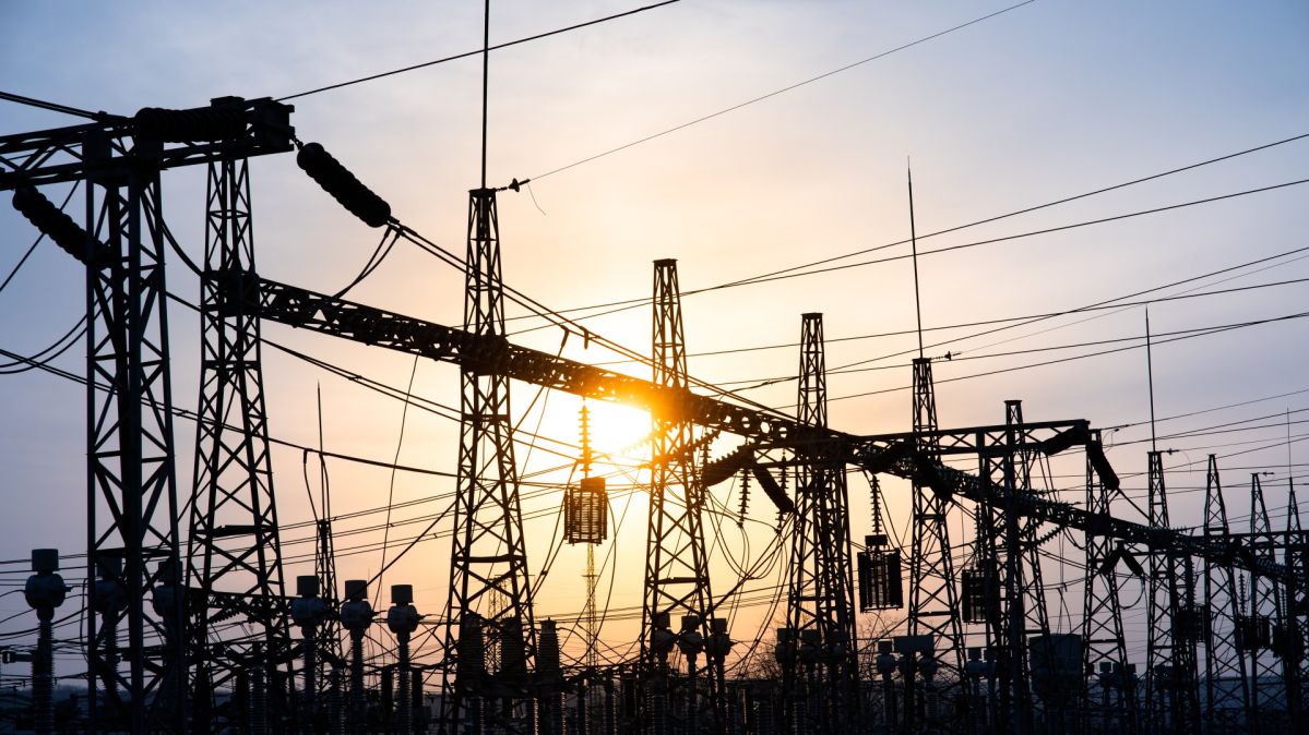Impression network at transformer station in sunset, high voltage up to blue sky take with blue tone, horizontal frame. electrical distribution stations