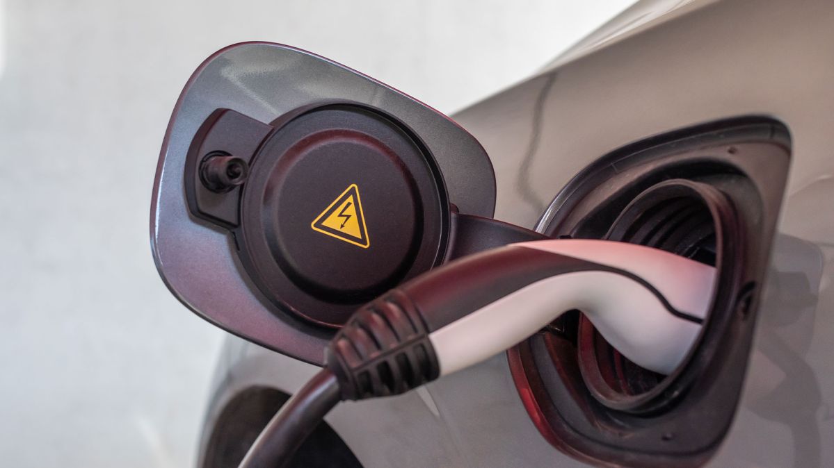 Ein E-Ladekabel lädt ein graues E-Auto.