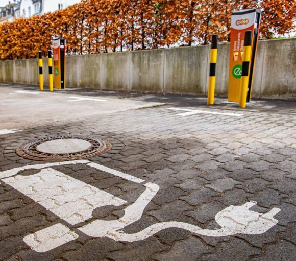 Ladesäulen Ehrenbreitsein orangene evm Ladestation mit Parkplatz davor