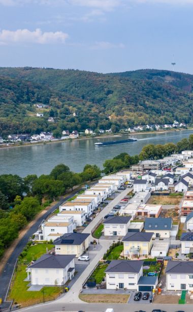 Himmelaufnahme auf ein Quartier mit mehreren Häusern und einer Baustelle eines mehrstöckigen Gebäudes.