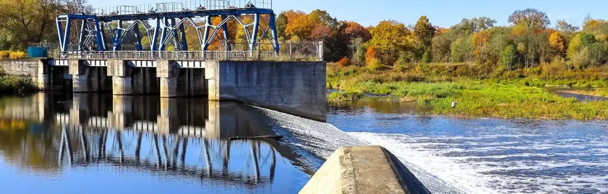 2216593721 Ninevija/Shutterstock Ein Wasserkraftwerk in einer grünen Umgebung mit einem blauen Himmel.
