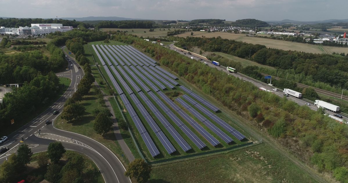 EVM-Solarpark G�rgeshausen Himmelblick auf einen Solarpark in einer begrünten Umgebung und blauem Himmel mit weißen Wolken.