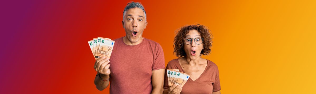 Ein Mann und eine Frau halten mehrere Geldscheine in der Hand und schauen sehr überrascht. Sie stehen vor einem orangenen Hintergrund.
