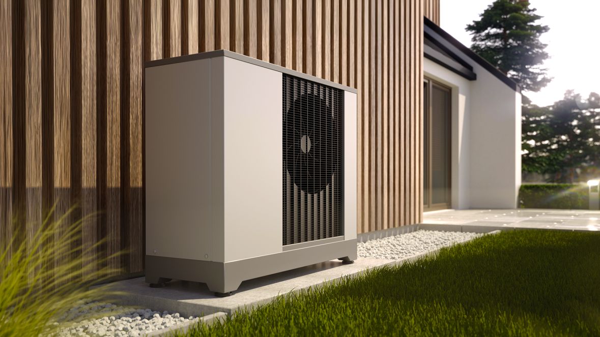 Wärmepumpe steht vor einem Haus im Garten