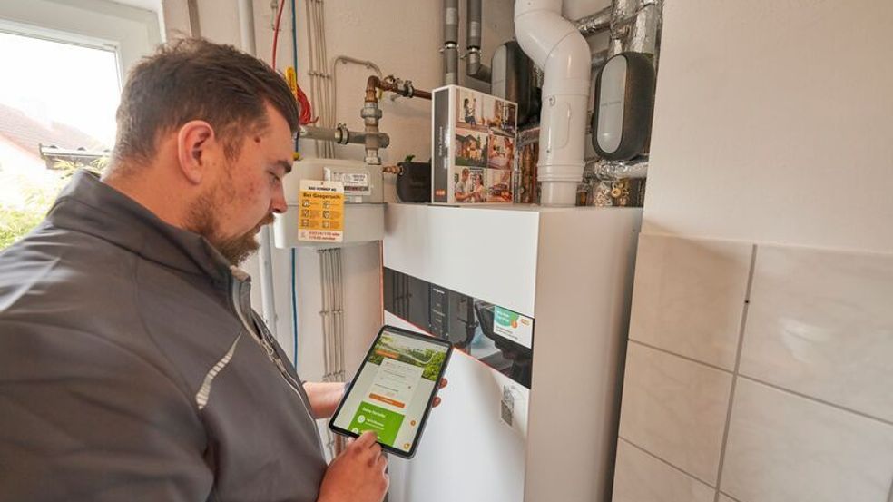 Ein Heizungsmonteur untersucht eine alte Heizung