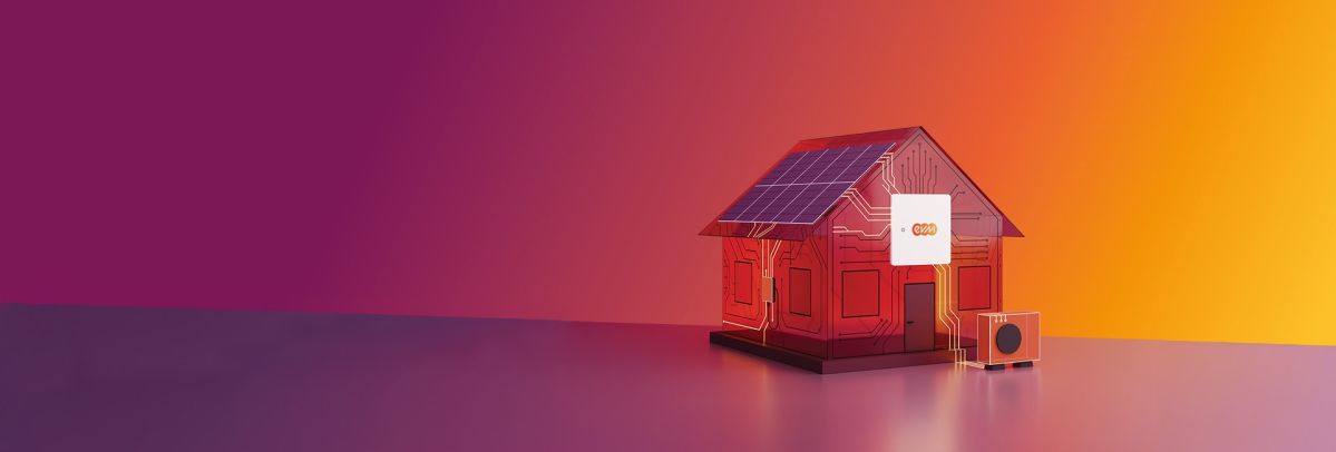 Ein stilisiertes Modellhaus mit Solarpanelen auf dem Dach steht auf einer glatten Fläche vor einem Farbverlauf aus Pink, Rot und Orange. Am Haus ist ein kleines Gerät mit dem evm‑Logo angebracht, daneben steht eine kompakte Wärmepumpeneinheit.