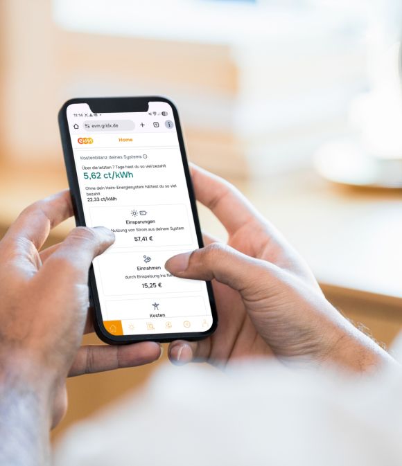 Günstig Mann hält Handy in der Hand und schaut sich die evm+ Energiepilot App an