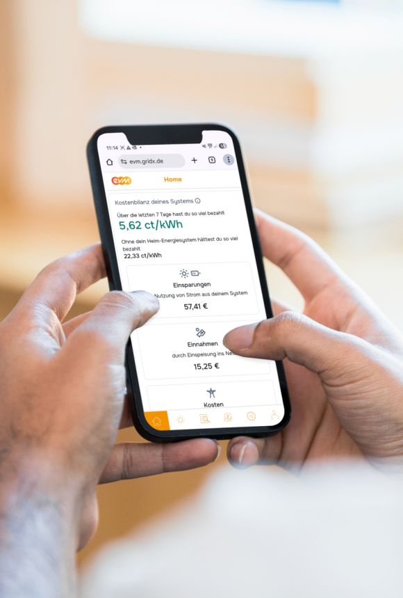 Günstig Mann hält Handy in der Hand und schaut sich die evm+ Energiepilot App an