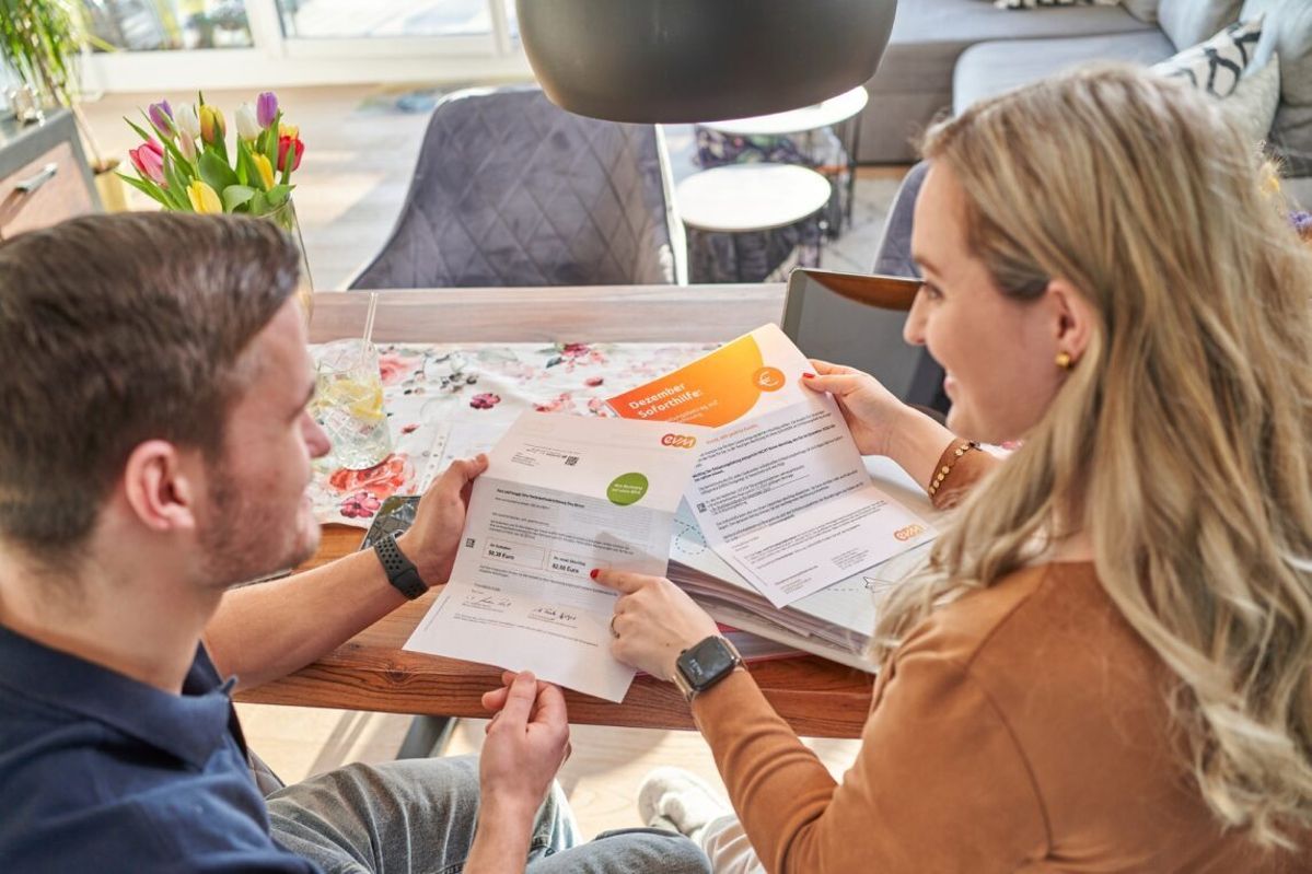 Wichtiger Nachtrag Zwei Personen von hinten mit einer Rechnung