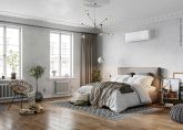 Ein modern eingerichtetes Schlafzimmer mit einem freistehendem Bett. Über dem Bett befindet sich eine weiße Klimaanlage.