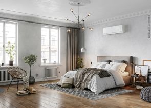 Ein modern eingerichtetes Schlafzimmer mit einem freistehendem Bett. Über dem Bett befindet sich eine weiße Klimaanlage.