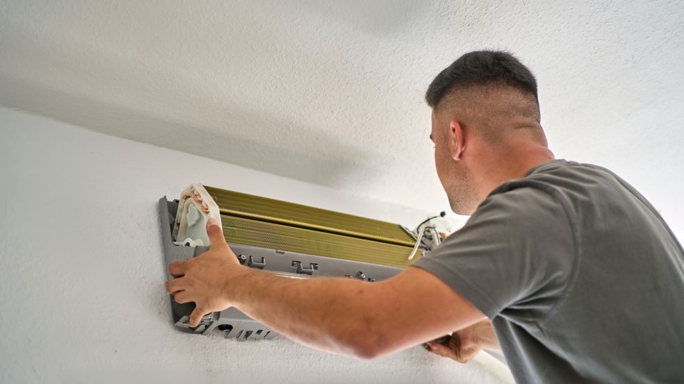 Ein Monteur der evms montiert eine Klimaanlage