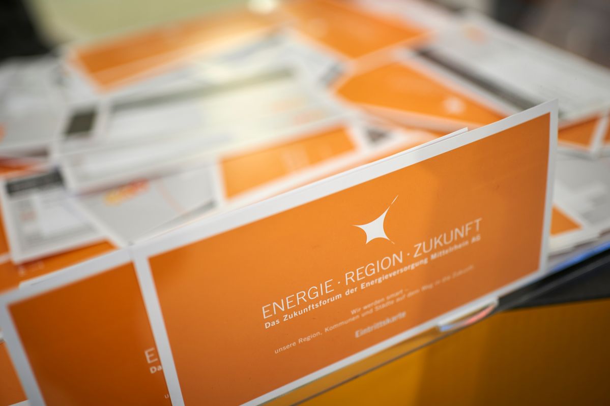 evm-Zukunftsforum 2019 Ein Stapel von orange-weißen Prospekten liegt auf einem Tisch. Auf dem vordersten Prospekt steht in weißer Schrift: "ENERGIE. REGION. ZUKUNFT. Das Zukunftsforum der Energieversorger."