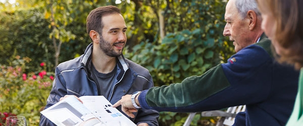 L&auml;chelnder evm-Mitarbeiter ber&auml;t ein &auml;lteres Ehepaar