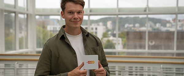 Ein junger Mann hält ein evm+ Energiepilot Gerät