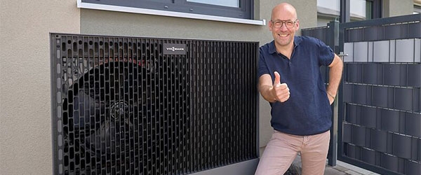 Thomas Schmitz steht glücklich vor seiner neuen Wärmepumpe