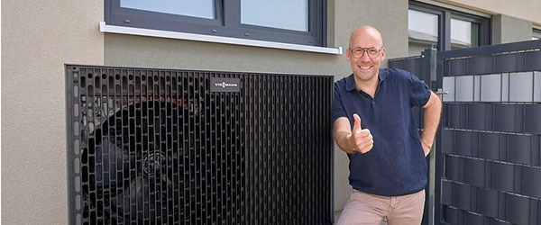 Thomas Schmitz steht glücklich vor seiner neuen Wärmepumpe