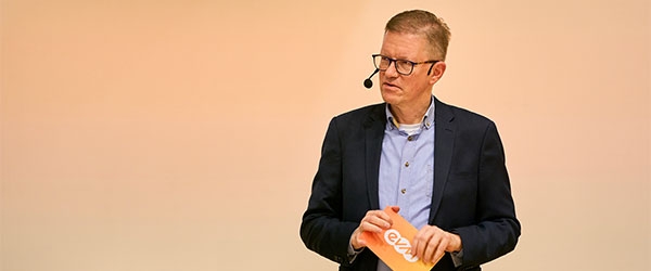 evm-Mitarbeiter mit Mikrofon und Gesprächsnotizen in der Hand