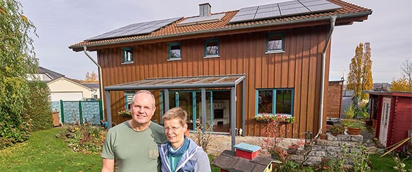 Familie Schneider vor ihrem Haus mit Solaranlage