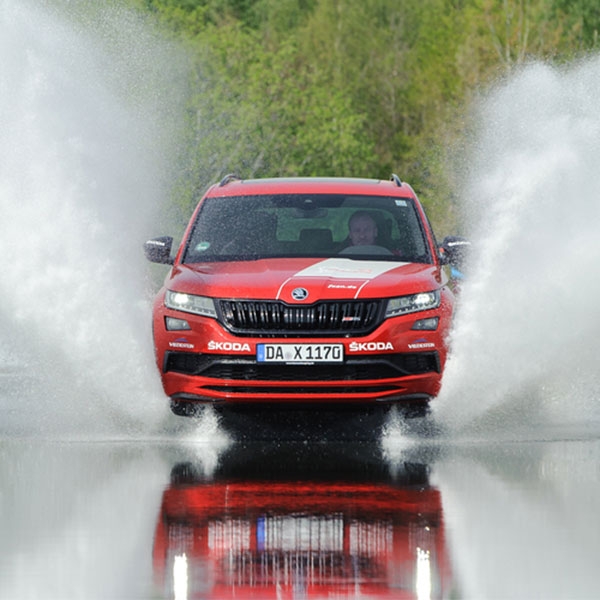 Ein rotes Auto das durch Wasser f&auml;hrt