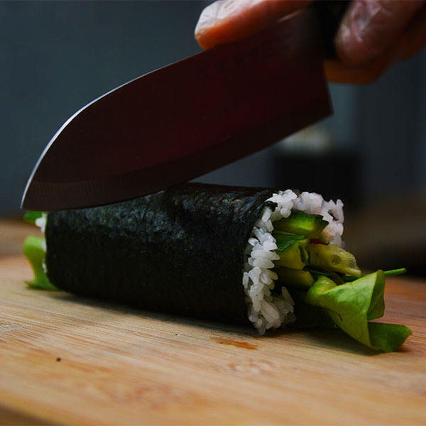 Eine Sushirolle wird geschnitten