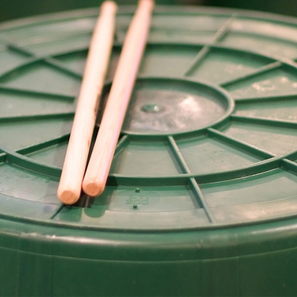 Drumsticks liegen auf einer Plastiktonne