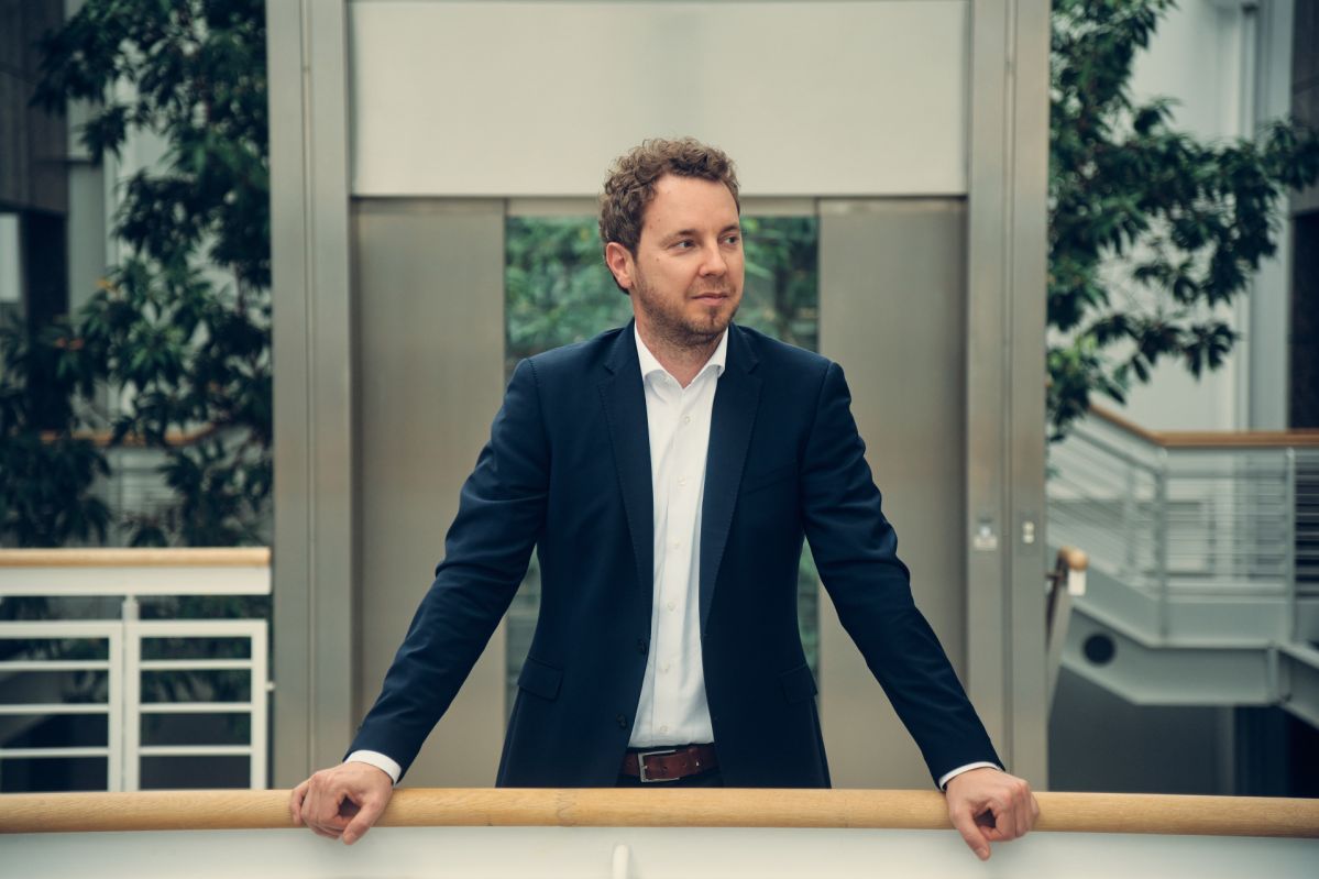 Vorstand der evm, Christoph Hesse, steht vor einem Geländer und blickt zum rechten Bildrand.