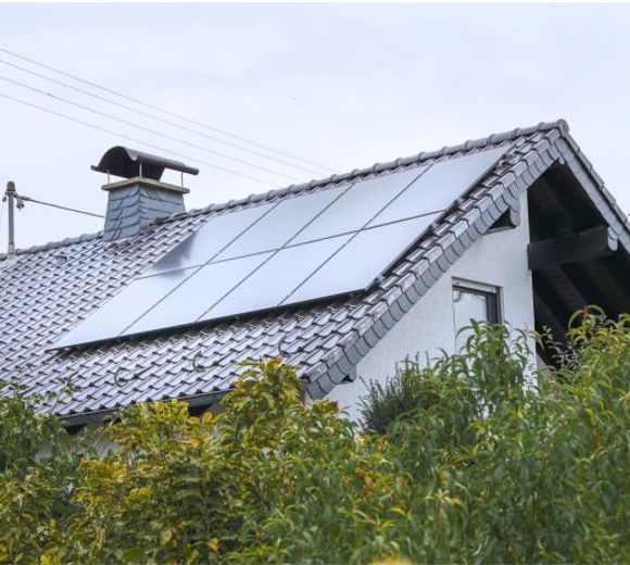 Ein Haus mit einer PV-Anlage auf dem Dach.