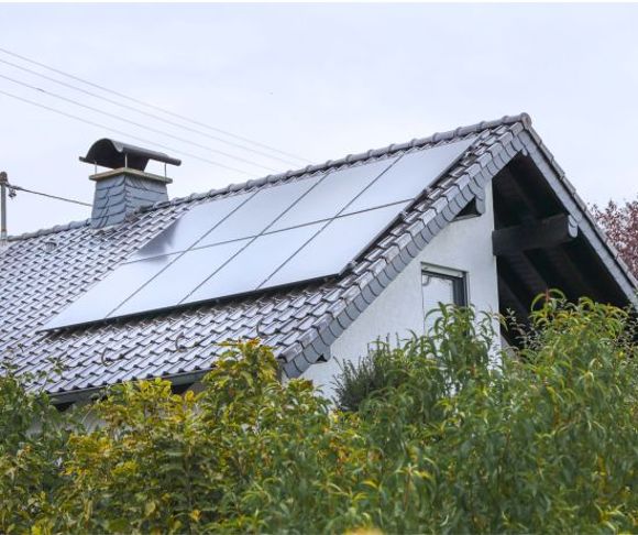 Ein Haus mit einer PV-Anlage auf dem Dach.