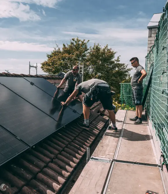 evm Handwerker montieren eine Solaranlage auf ein Dach.