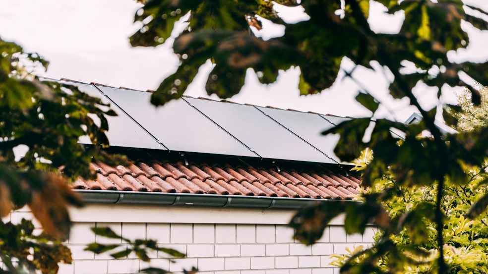 Ein Hausdach, das mit eine Solaranlage eingedeckt ist
