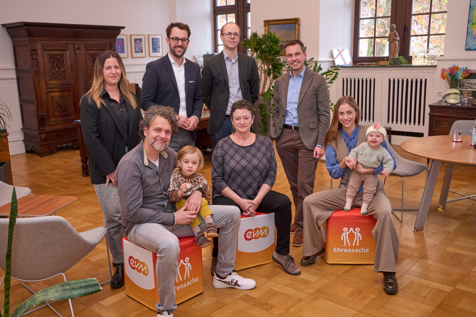 evm Ehrensache Koblenz Gruppe mit sieben Erwachsenen und zwei Kindern im historischen Rathaus Koblenz bei der Spendenübergabe evm Ehrensache