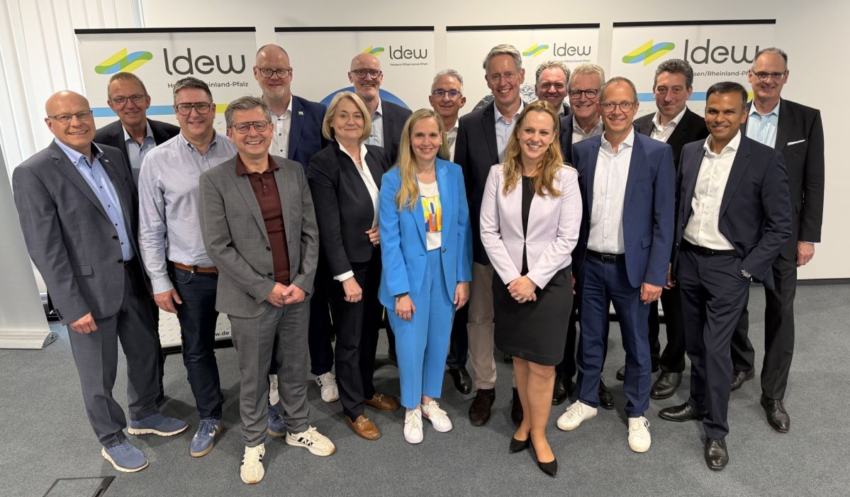 Vorstand des LDEW Mehrere Personen aus dem Vorstand des LDEW stehen bei einer Mitgliederversammlung vor LDEW-Rollups für ein Gruppenfoto; Mithun Basu ist als zweiter von rechts Teil der Gruppe.