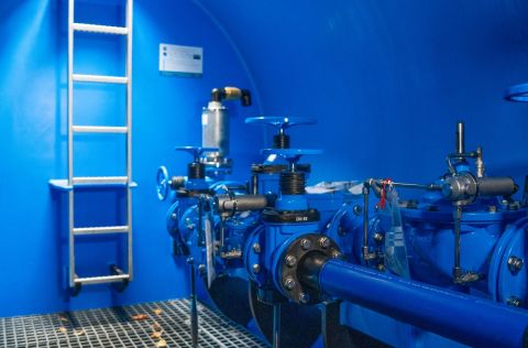 Im Inneren des neuen Druckminderungsschachts sind blaue Rohrleitungen, Armaturen und Regeltechnik zu sehen. Die Anlage gleicht Schwankungen im Eingangsdruck aus und sorgt für einen konstanten, niedrigeren Ausgangsdruck, um die Trinkwasserversorgung langfristig zu sichern.