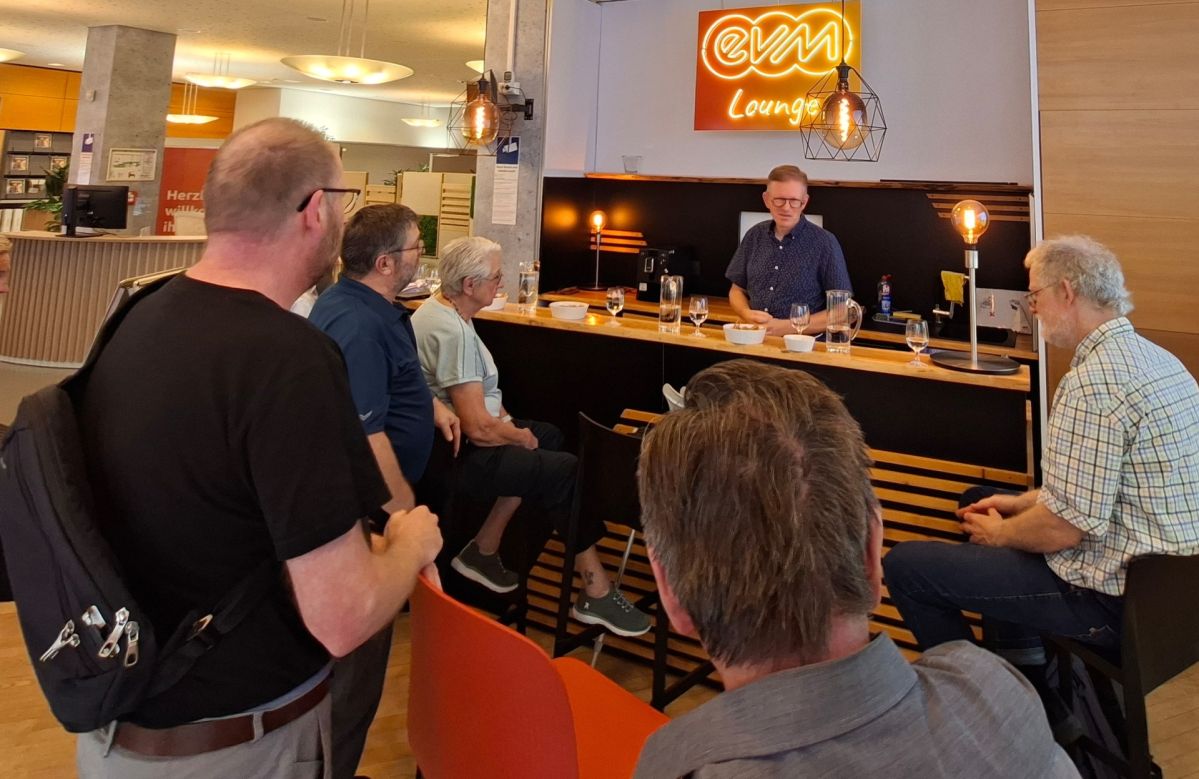 Energietreff Mehrere Besucherinnen und Besucher sitzen und stehen in der evm‑Lounge im Kundenzentrum der Energieversorgung Mittelrhein (evm) in Koblenz. Marcelo Peerenboom, Leiter der Stabsstelle Kommunikation der evm, beantwortet im Rahmen des ersten „Energietreffs“ Fragen rund um Energiewende, Smart Meter, Gasnetze und die zukünftige Energieversorgung.