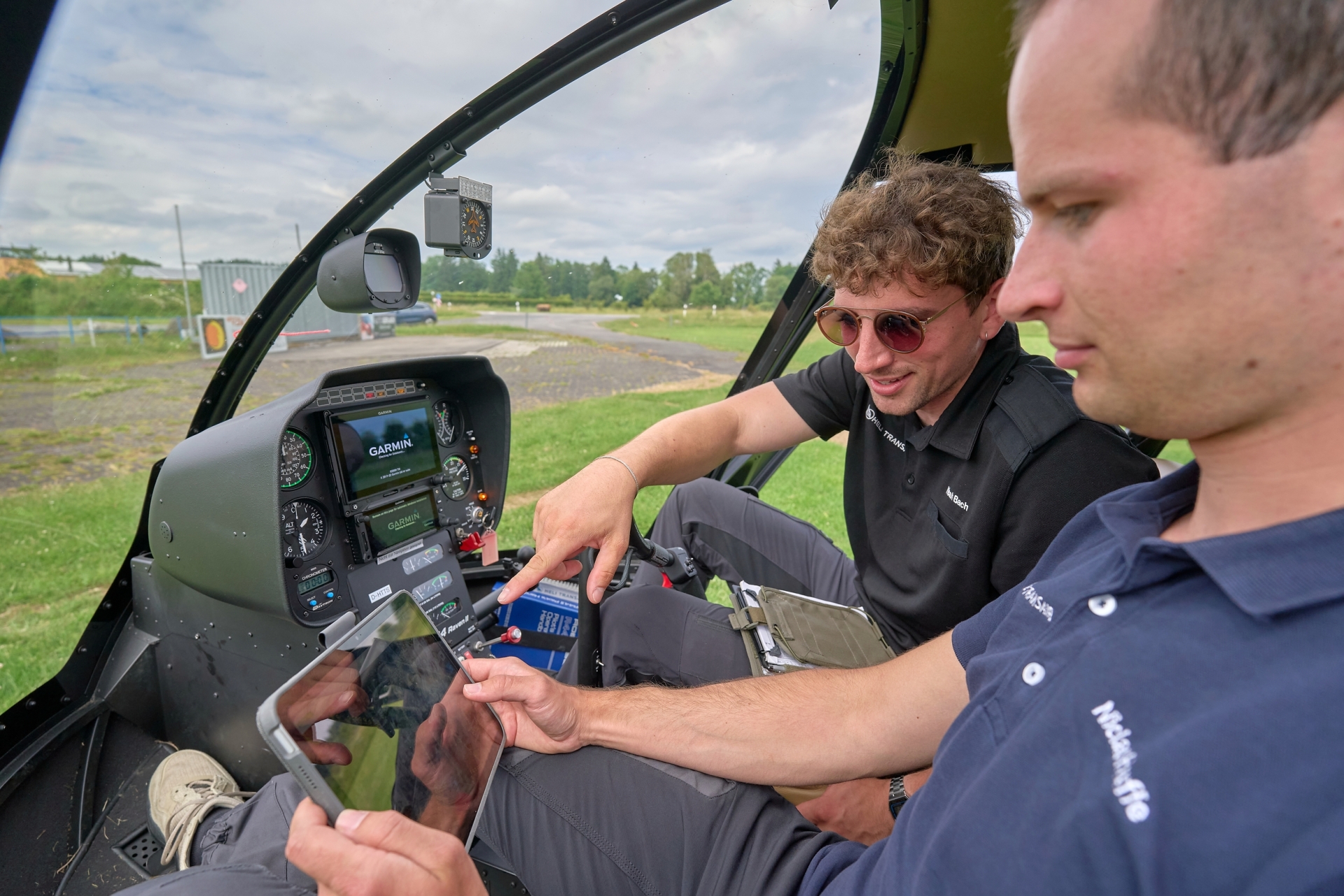 Zwei Crewmitglieder prüfen im Cockpit anhand digitaler Karten die Flugroute für die Leitungsinspektion zwischen Eifel und Westerwald.