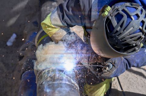 Gasleitung im Niederdrucknetz Eine Fachkraft führt Schweißarbeiten an einer Gasleitung durch, während Funken und Rauch aufsteigen – ein wichtiger Schritt bei der Einbindung in das Niederdrucknetz.
