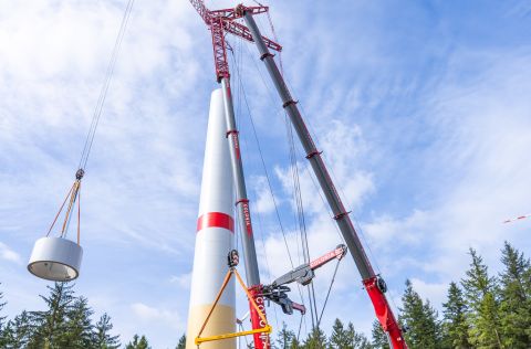 Turmbau Windpark Schneifelhöhe Mehrere Großkräne errichten auf der Baustelle des Windparks Schneifelhöhe einen Betonturm für eine Windenergieanlage. Einzelne Turmsegmente werden mit Hilfe der Kräne aufeinandergesetzt. Die Anlage entsteht auf einem Fundament im Waldgebiet der Schneifelhöhe und ist Teil des Windparks mit insgesamt elf Windenergieanlagen.