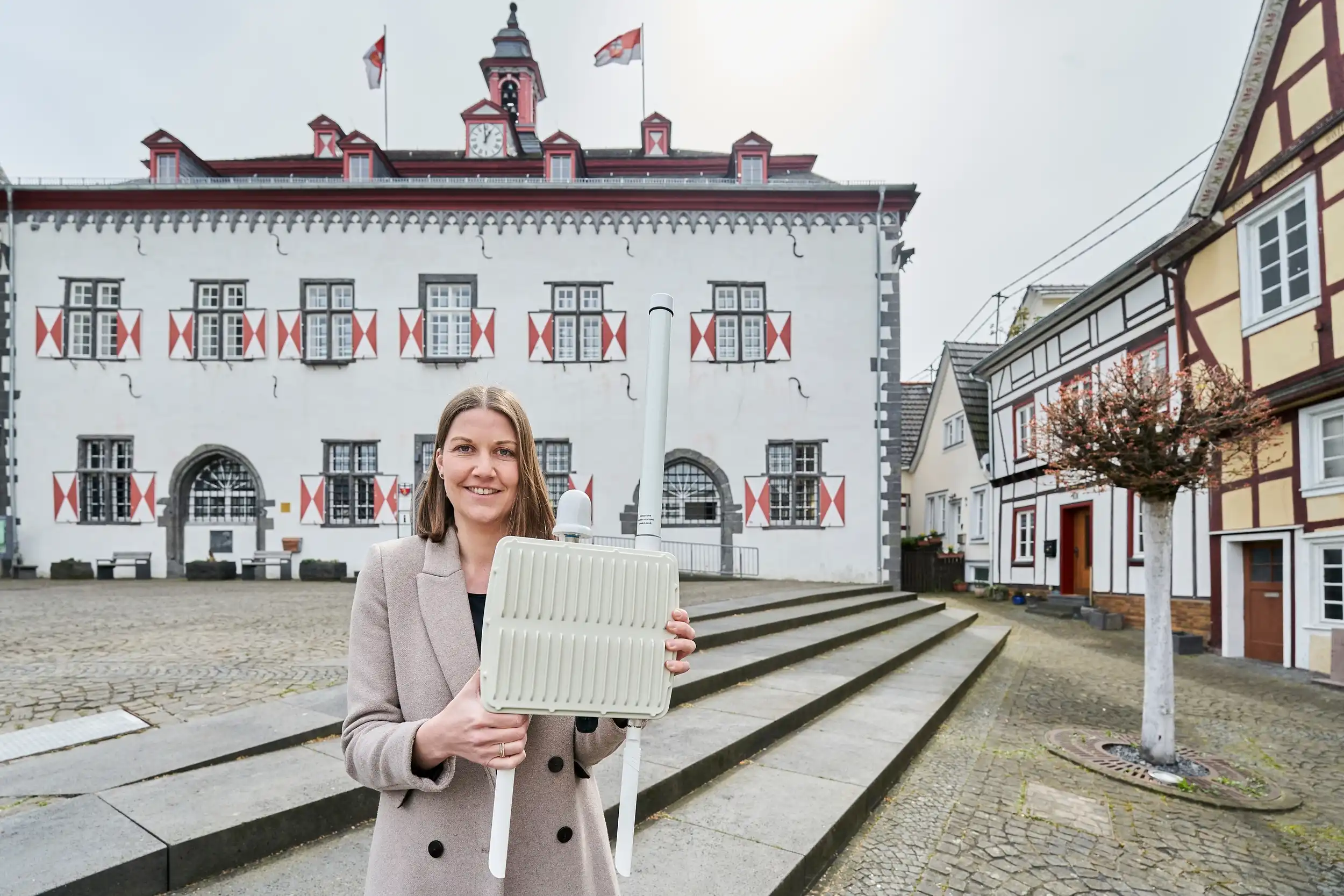 Aufbau LoRaWAN-Netz für die Smart-City Linz am Rhein Karin Wessel mit der Funkantenne vorm Rathaus Linz