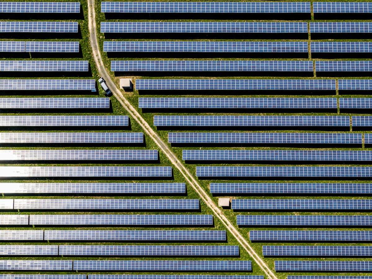 EVM-20180420-Solarpark Hachenburg-010 Himmelblick von einem Solarpark. In der Mitte führt ein kleiner Weg entlang der Solarpanele.