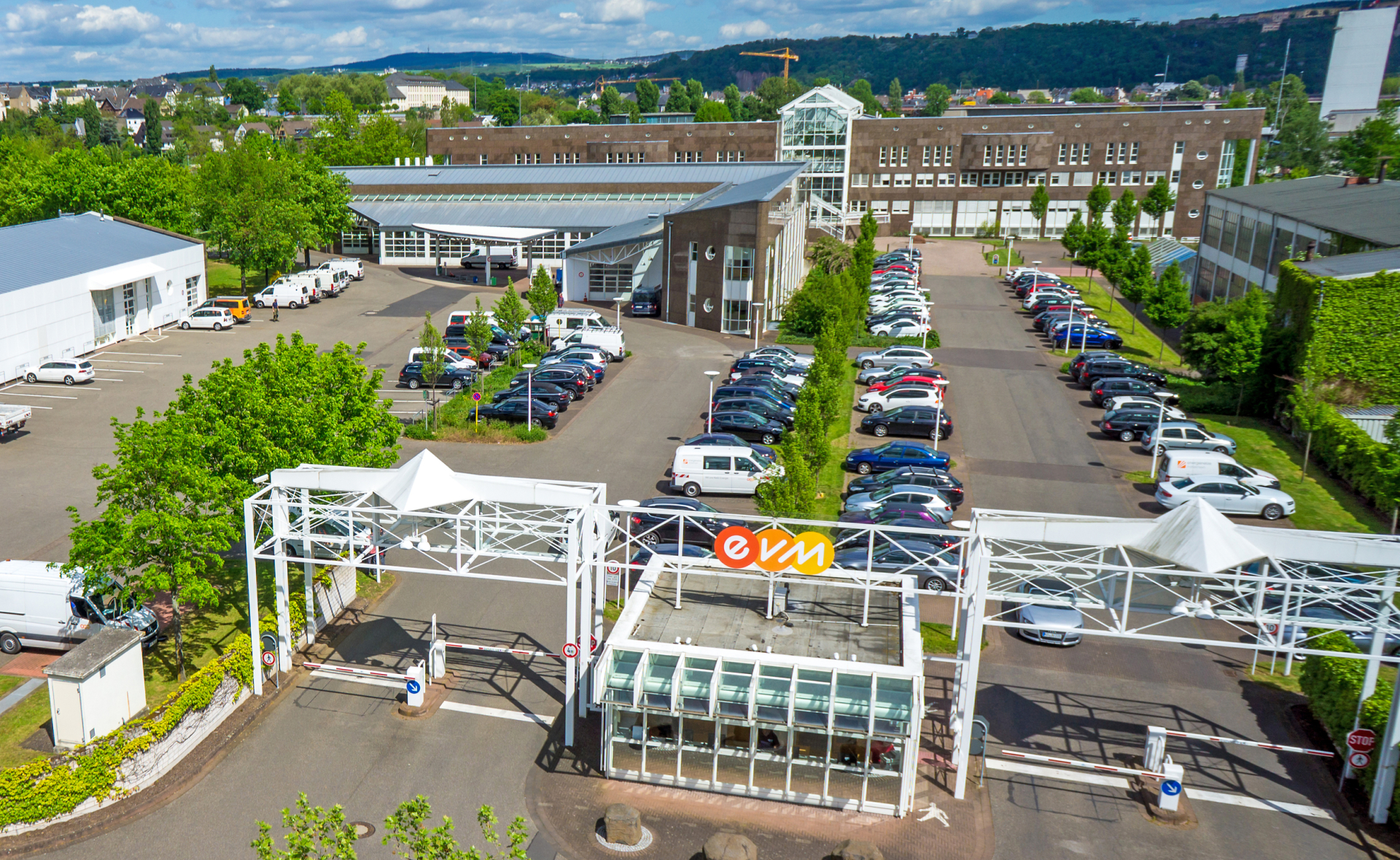 Luftaufnahme der evm Hauptverwaltung mit Parkplätzen, begrünten Bereichen und mehreren Gebäuden.