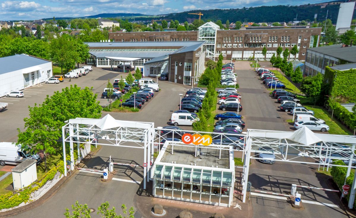 Luftaufnahme der evm Hauptverwaltung mit Parkplätzen, begrünten Bereichen und mehreren Gebäuden.