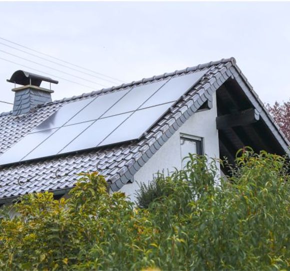 Ein Haus mit einer PV-Anlage auf dem Dach.