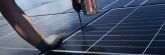evm Handwerker montieren eine Solaranlage auf ein Dach.