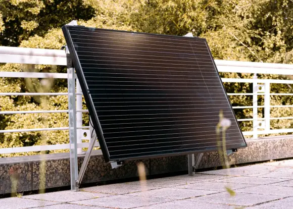 Ein Solarpanel ist an einem Balkongelände montiert.