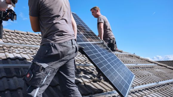 evm Handwerker montieren eine Solaranlage auf ein Dach.