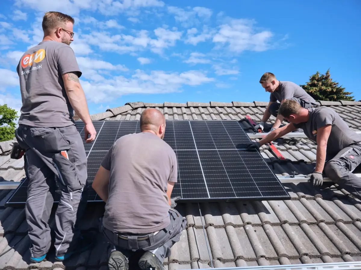 evm Handwerker montieren eine Solaranlage auf ein Dach.