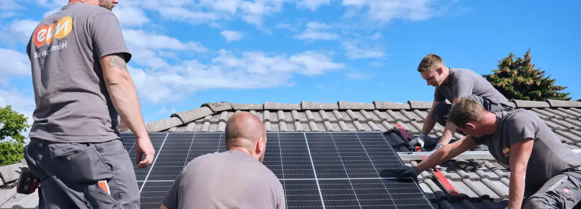 evm Handwerker montieren eine Solaranlage auf ein Dach.
